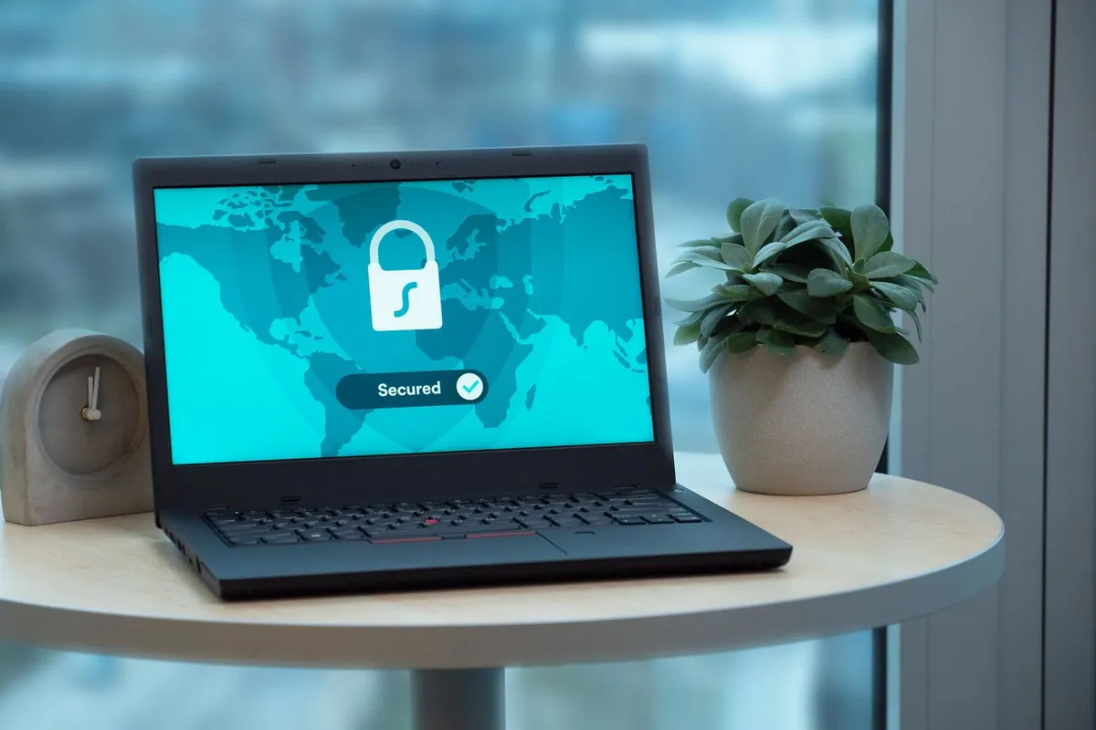 En laptop som viser et sikkerhets- og låsikon på en pult.